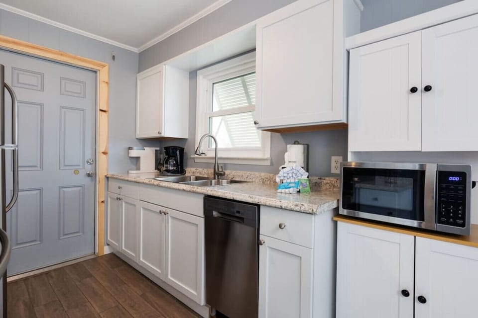 The sleek white kitchen has all the clean lines and granite space you need to actually enjoy cooking (or just pretend to while you`re on vacation).