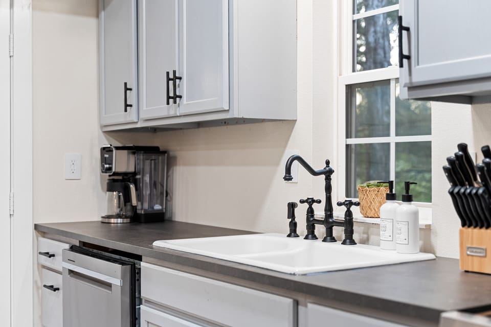 The kitchen has modern gray cabinets and a farmhouse-style sink.