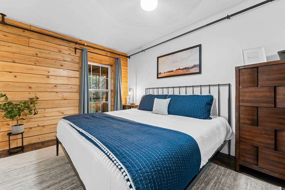 This main-level bedroom has a king bed. Get ready to unwind with the luxurious linens and pillows. Each bedroom has a TV.