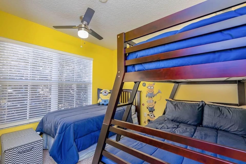 Upper-level room with full-over-twin bunk, single twin, and Minion touches.