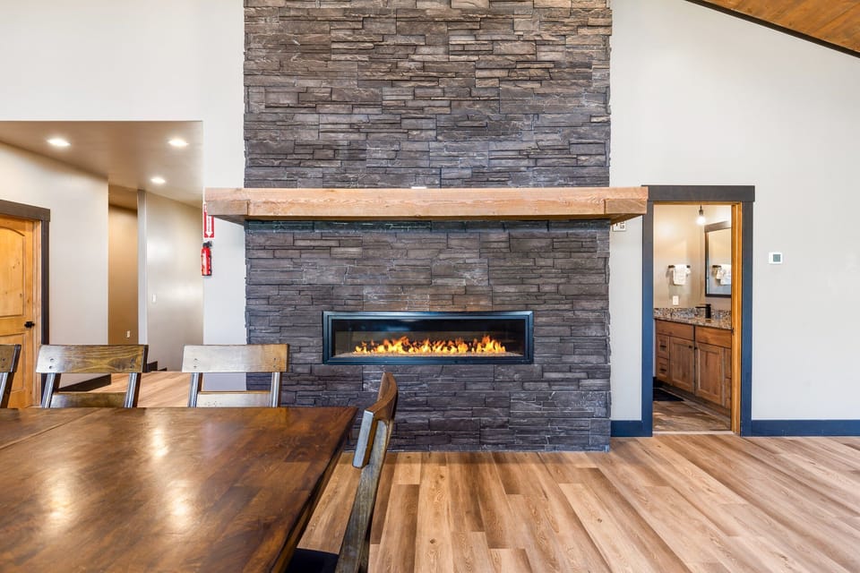Enjoy the floor to ceiling stone fireplace while sharing a meal | Upper Level