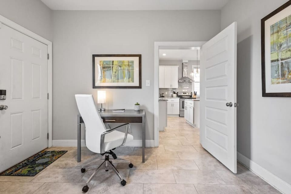 Office nook beside the kitchen with desk setup, laundry closet, and door leading to the backyard.