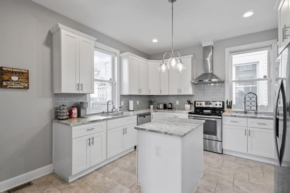 Modern, full size kitchen with ample cabinet and drawer space boasting fridge, freezer, kitchen island, Keurig, drip coffee maker, toaster, oven, stove and more!