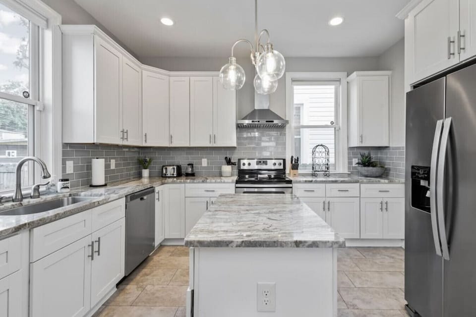 Modern, full size kitchen with ample cabinet and drawer space boasting fridge, freezer, kitchen island, Keurig, drip coffee maker, toaster, oven, stove and more!