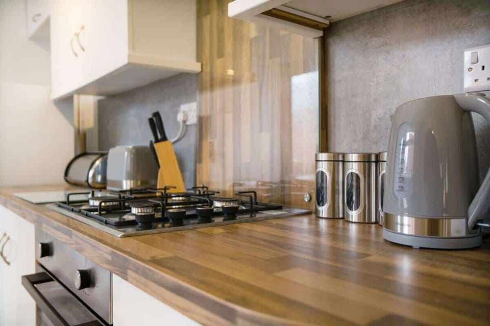 Kitchen equipped with all essentials, including an oven, stovetop, fridge, kettle, and toaster.