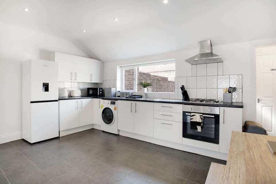 Kitchen equipped with all essentials, including a washer & dryer, oven, fridge and full cookware set.