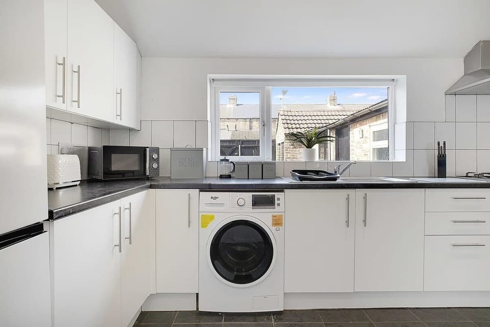 Kitchen equipped with all essentials, including a washer & dryer, oven, fridge and full cookware set.