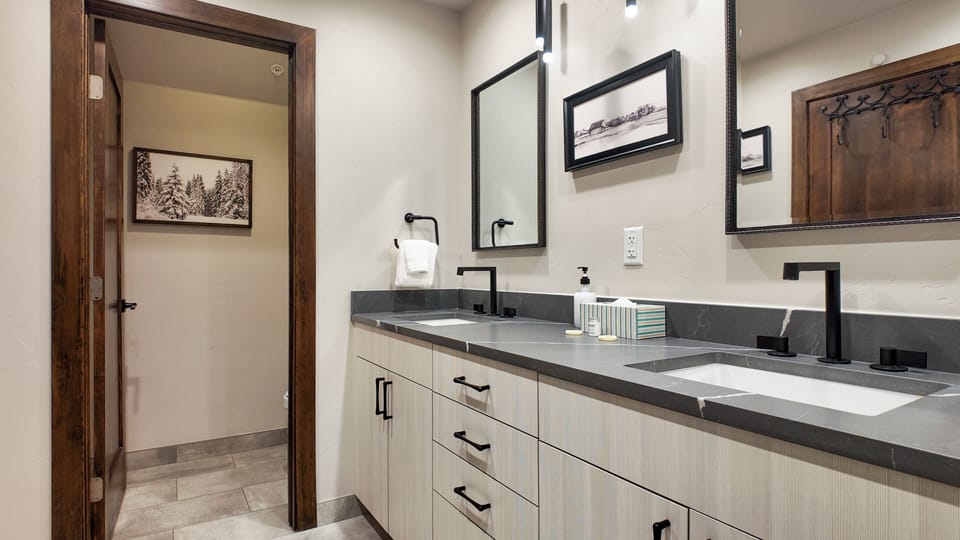Full bath with double-sink vanity, modern lighting, and clean design.