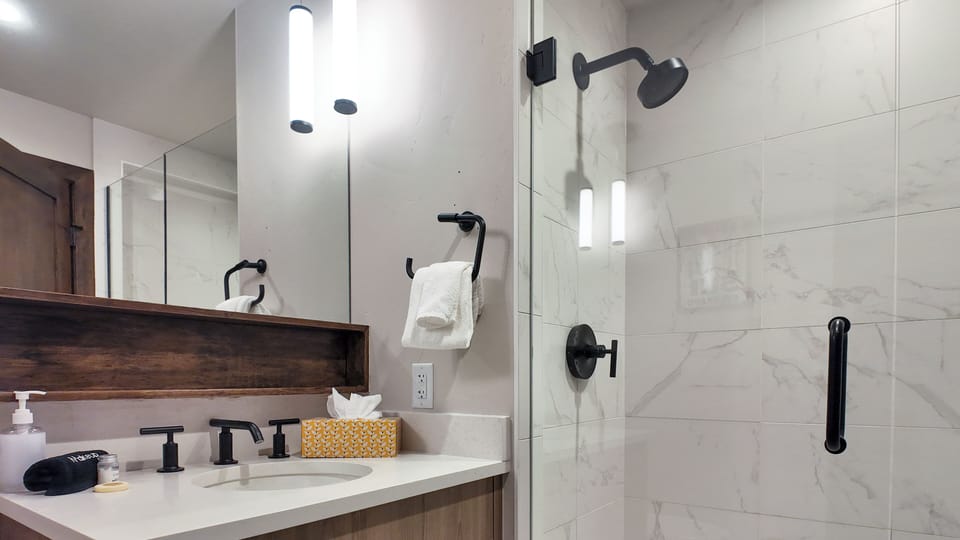 Full bath with walk-in shower, modern fixtures, and bright vanity.