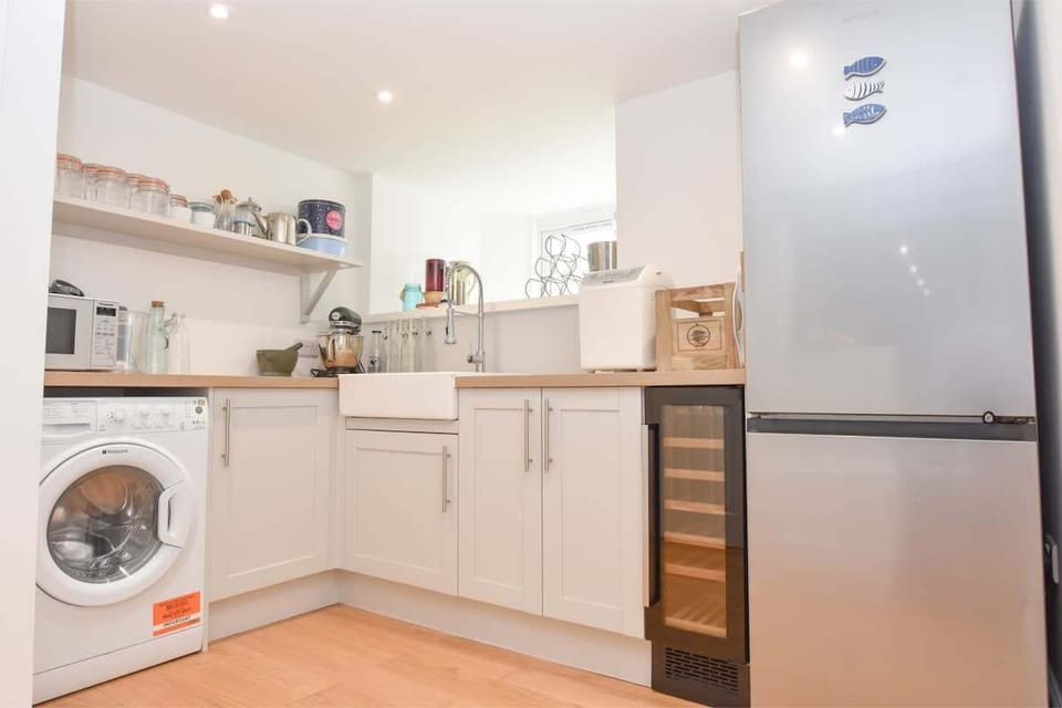 Utility room with washer/dryer, fridge, wine cooler and additional storage space on the lower ground floor.

