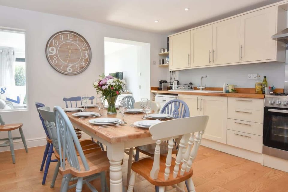 Modern open‑plan kitchen and dining room with stylish appliances and generous seating for shared meals.
