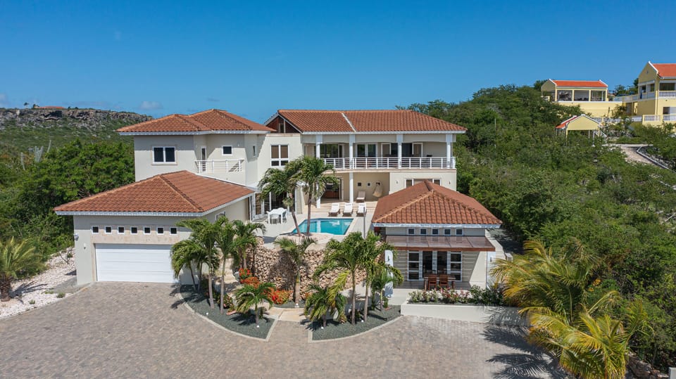 This new villa has over 8,700 SqFt of living space and manicured palm gardens
