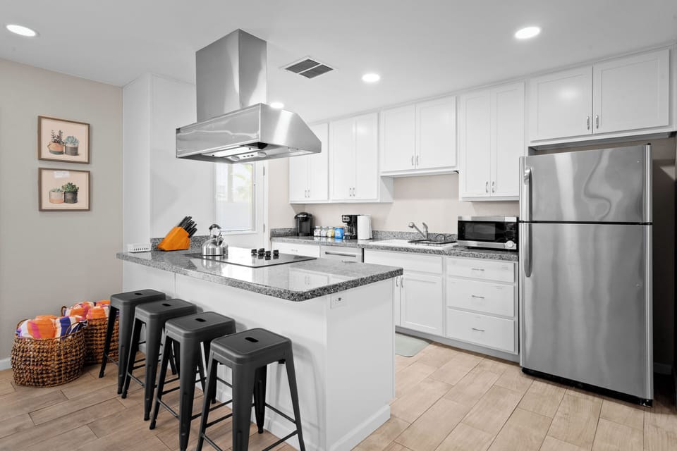 Fully stocked kitchen with bar seating and sleek stainless steel.