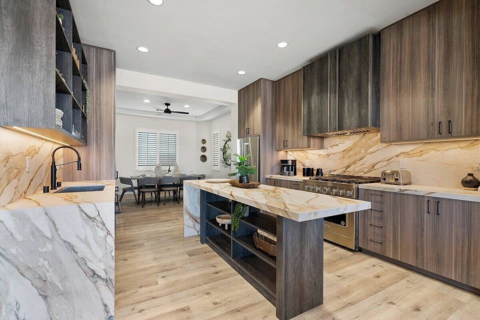 Top of the line kitchen with custom slab and Italian cabinetry, waterfall island, double dishwashers, and commercial quality range and oven.