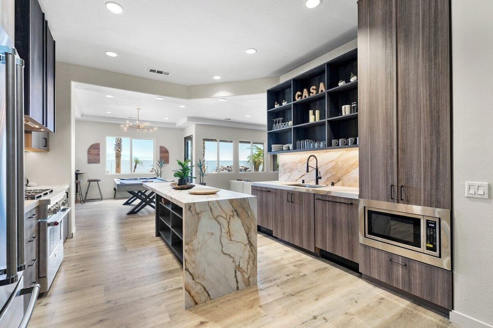 A top of the line commercial-style kitchen with custom Italian cabinetry, waterfall island and commercial-grade appliances with a double dishwasher for easy entertaining.