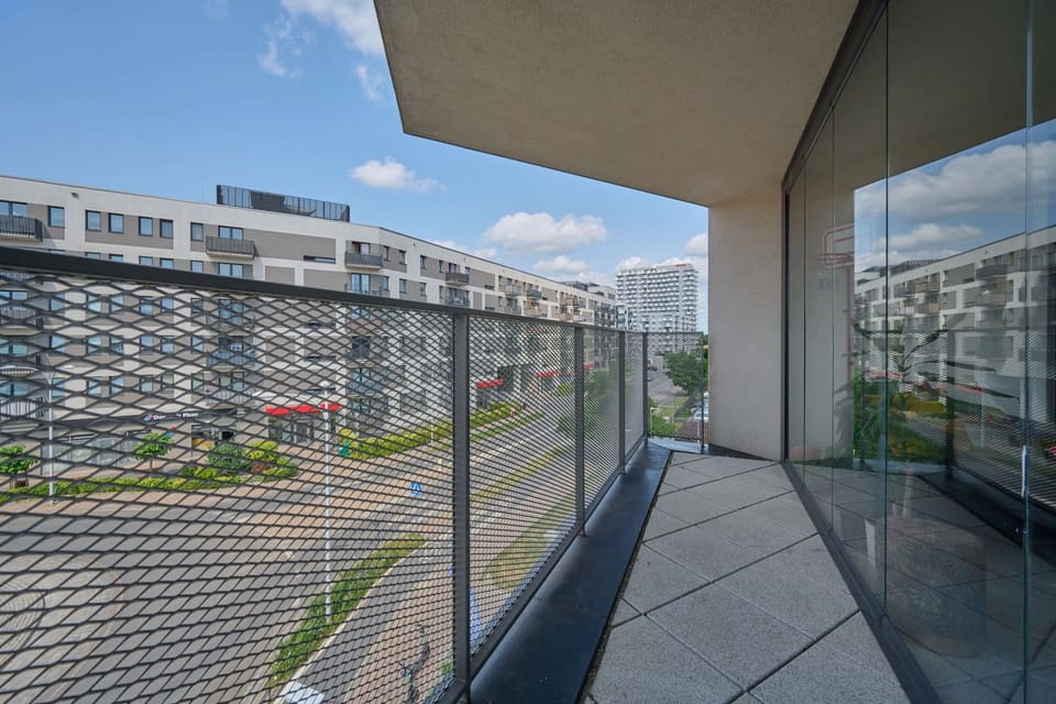 A wide view of the balcony and the vibrant cityscape in the background.






