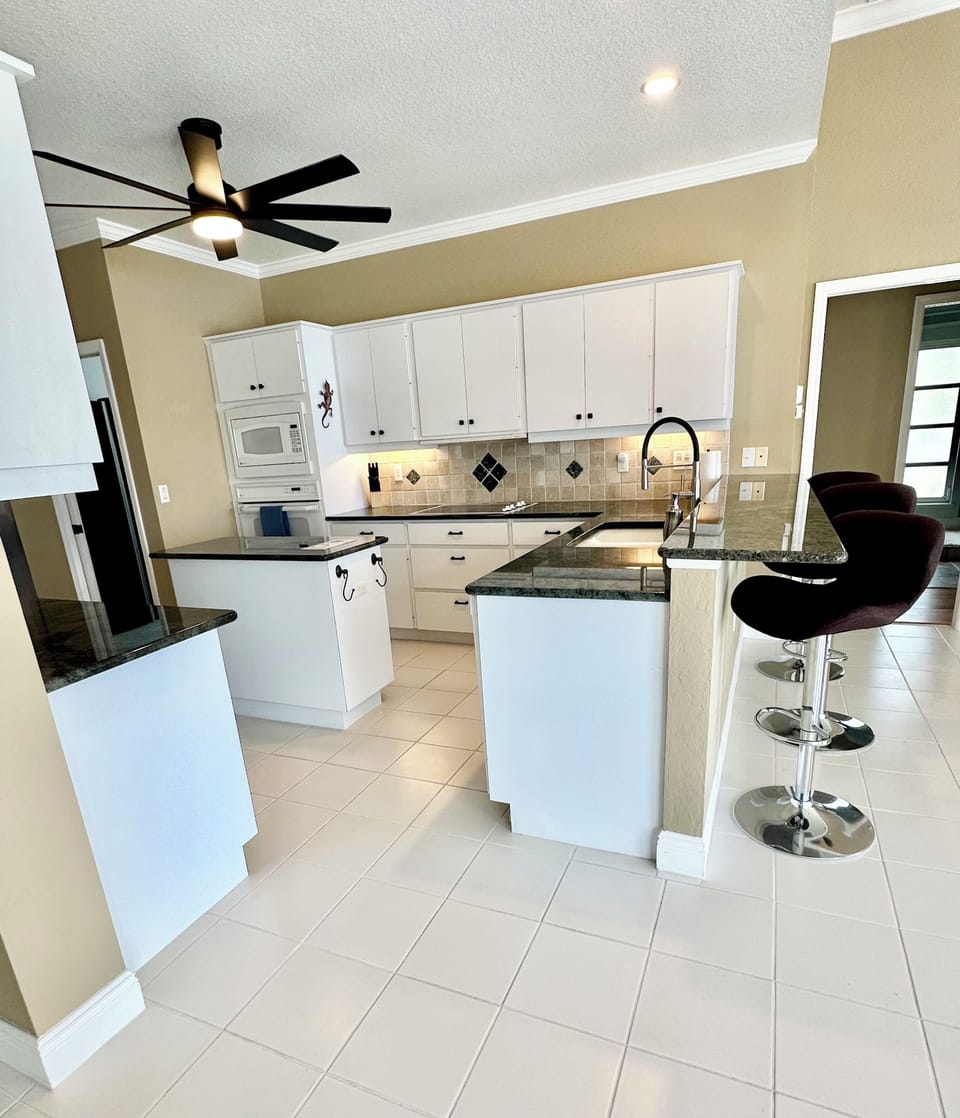 BRIGHT, OPEN KITCHEN WITH GRANITE TOPS AND A BREAKFAST BAR