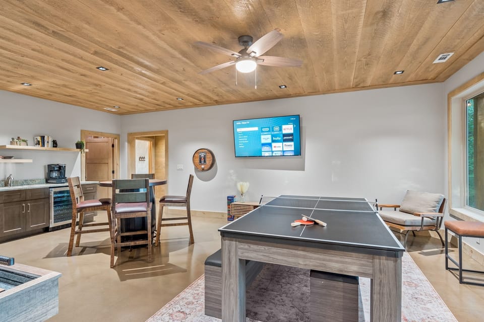 Game room with ping pong topper over pool table and pub table