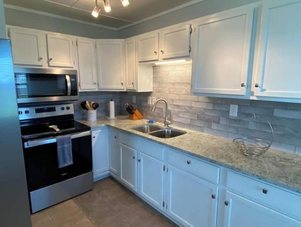 Kitchen features new refrigerator, stove an microwave