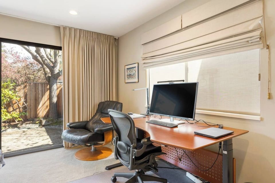 Large sit-stand desk with monitor, keyboard, mouse, and printer