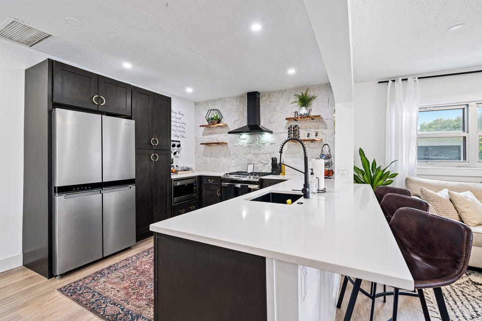 Fully equipped kitchen with open shelving and modern appliances.