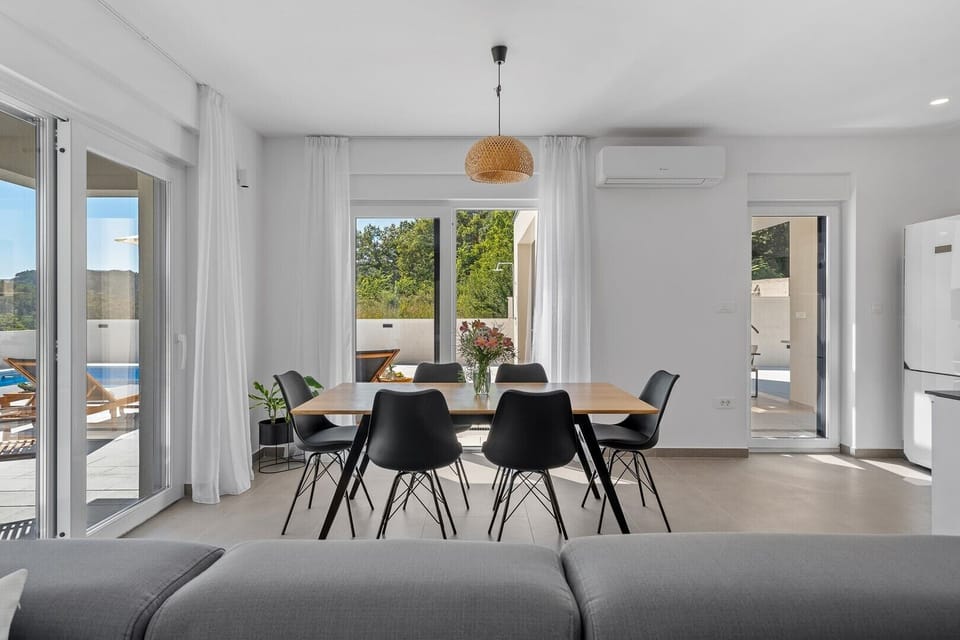 a dining area with a table for 6 people, and a covered terrace with two chairs