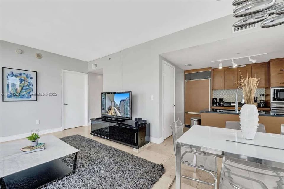 Relax in this chic living room with city views, smart TV, and lush greenery—ideal for couples or solo travelers.

