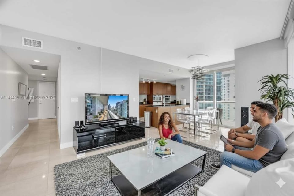 Modern vacation rental with cozy seating, skyline views, and a sleek kitchen—perfect for relaxing, hosting, or enjoying city life with friends.