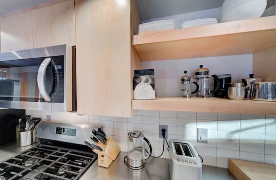Main level: French press, grinder, and locally-roasted coffee beans.