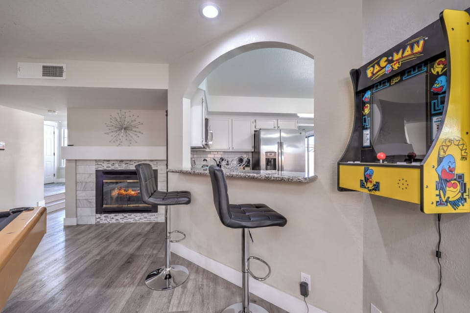 Game-ready lounge with bar seating, fireplace, and modern kitchen