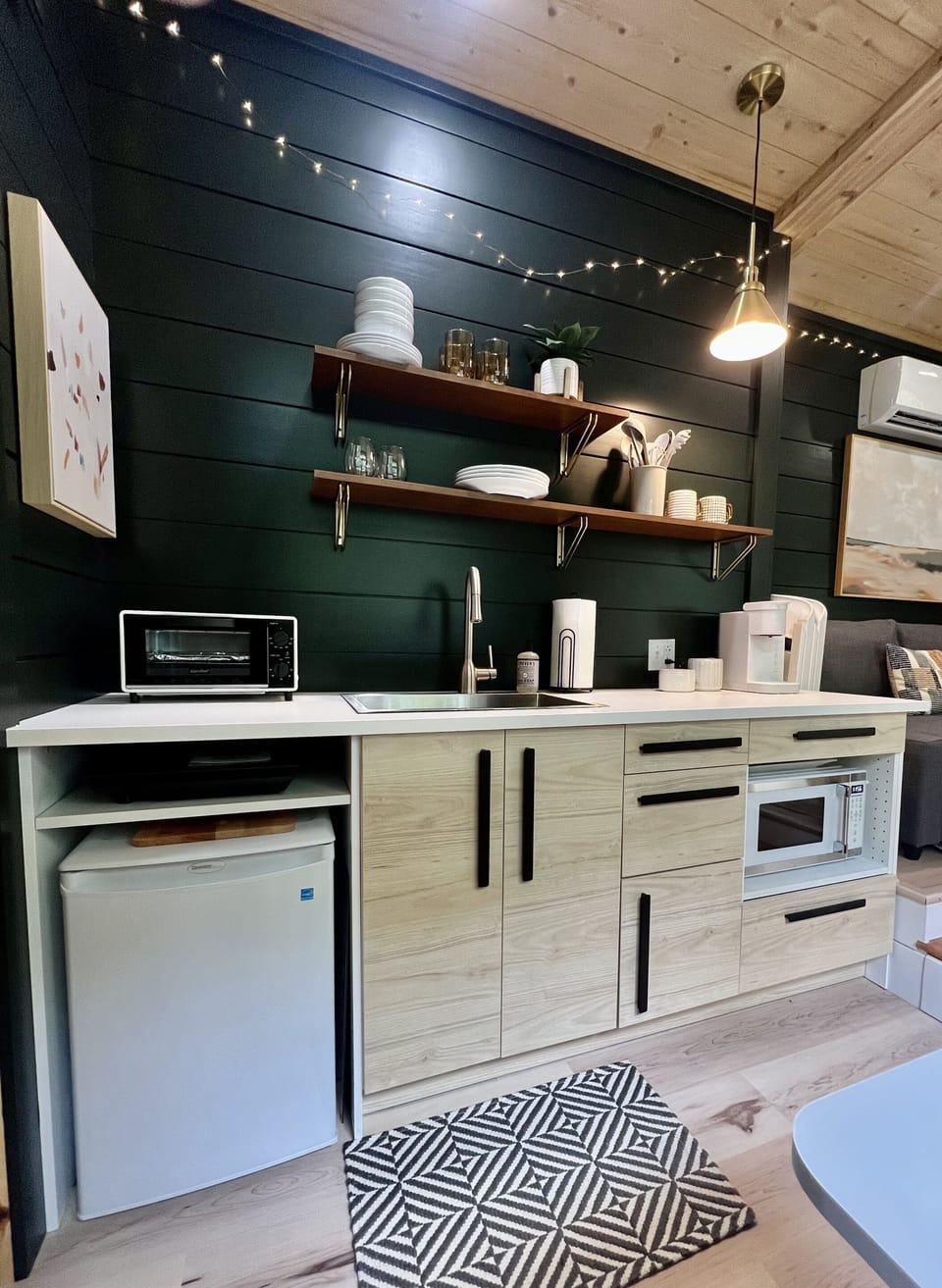 The kitchen includes microwave oven, toaster oven, portable cooktop, mini-refrigerator, plenty of counter space, and all the pots, pans, flatware, and silverware needed to prepare and eat great tiny-home-cooked meals.  