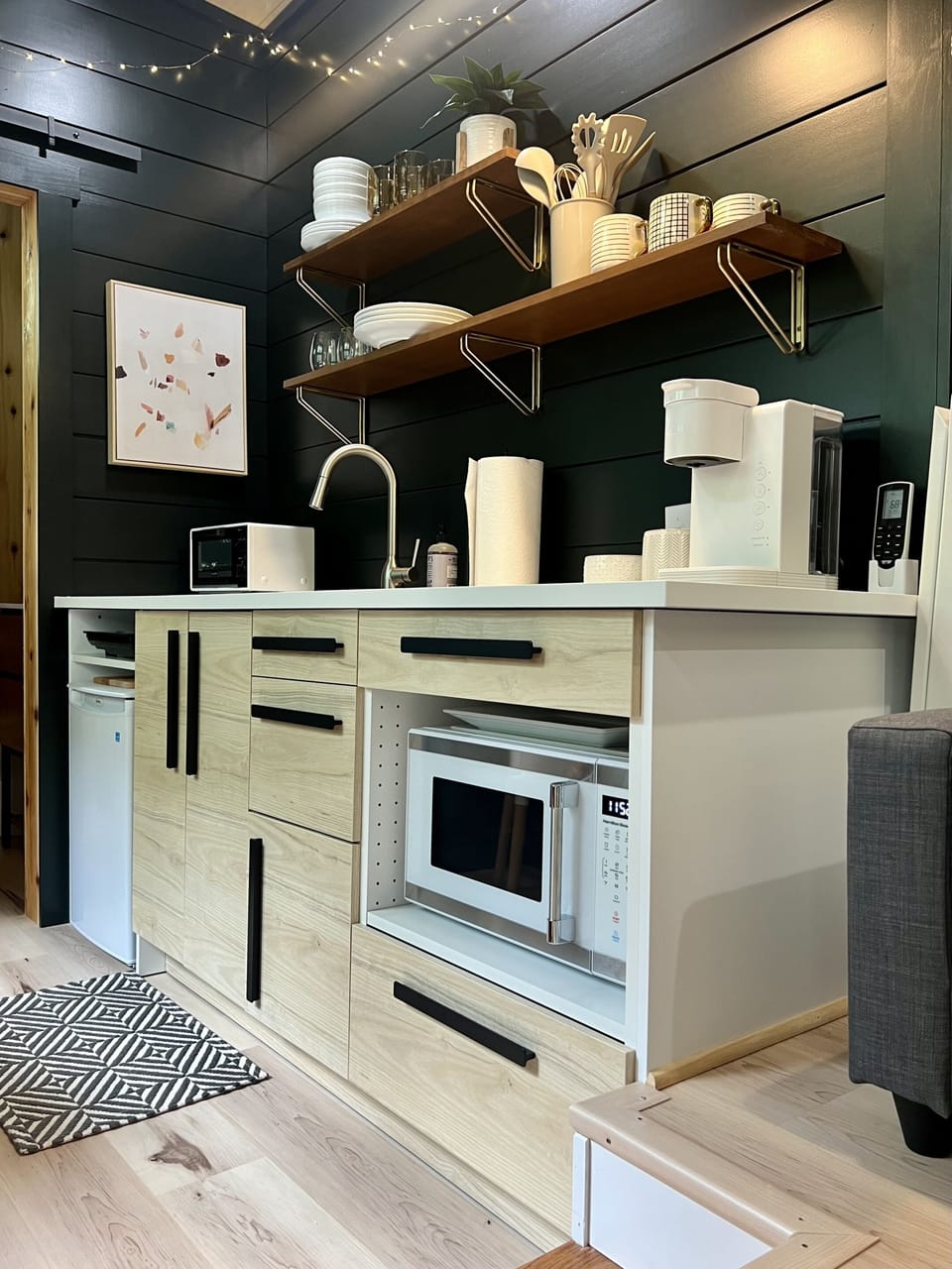 The kitchen includes microwave oven, toaster oven, portable cooktop, mini-refrigerator, plenty of counter space, and all the pots, pans, flatware, and silverware needed to prepare and eat great tiny-home-cooked meals.  