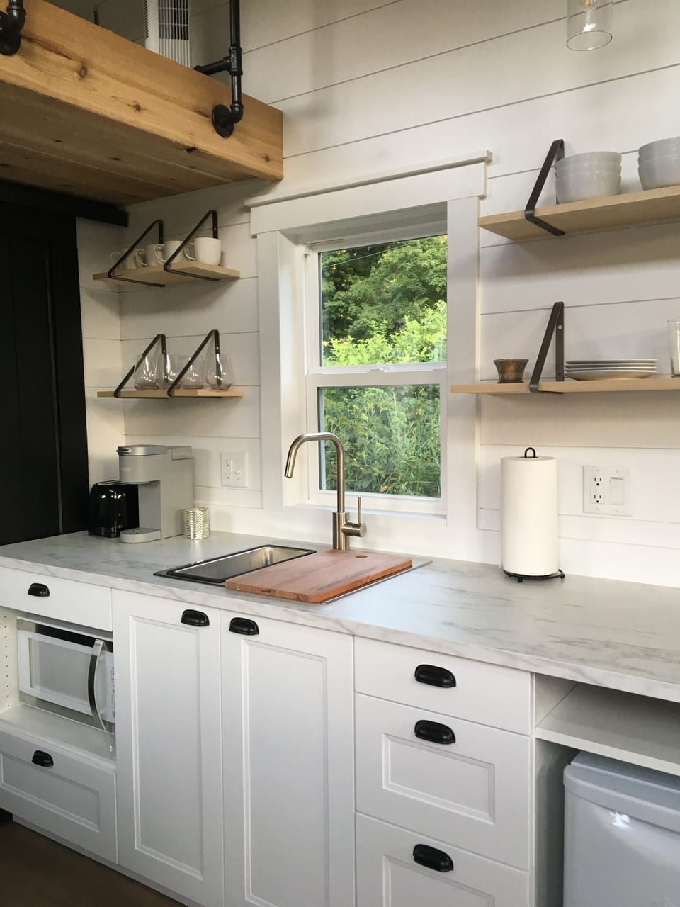 The kitchen includes a microwave, toaster, mini-refrigerator, stovetop (with pots and pans), a Keurig coffee maker (with basic coffee pods), and plenty of space to make and prepare a meal.  