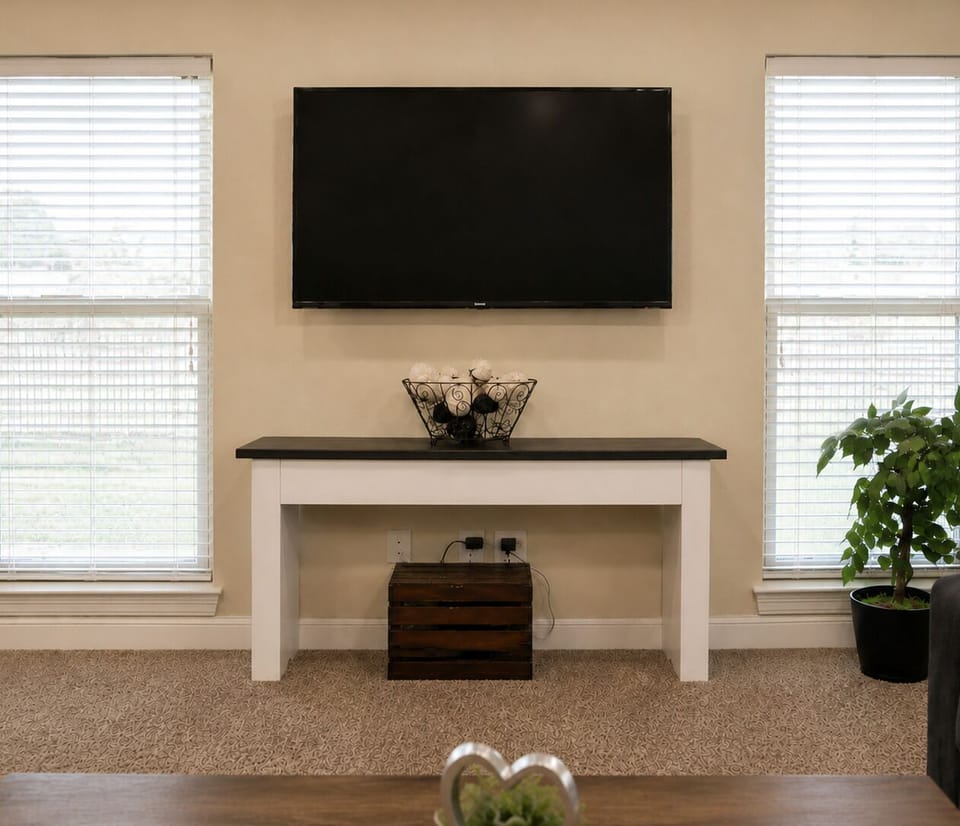 Bright living area with large TV, natural light, and modern console table