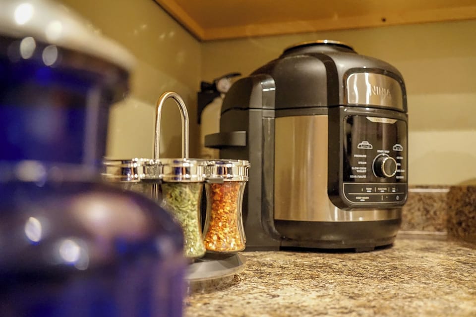 Modern kitchen setup with Ninja cooker and convenient spice station