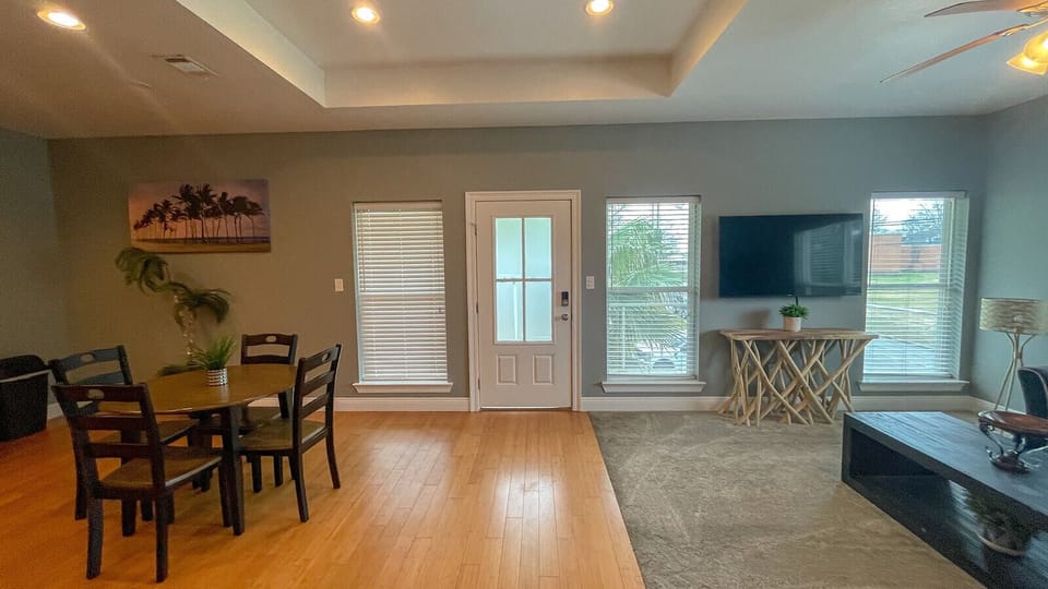 Bright open living & dining area with TV, natural light, and seating for 4