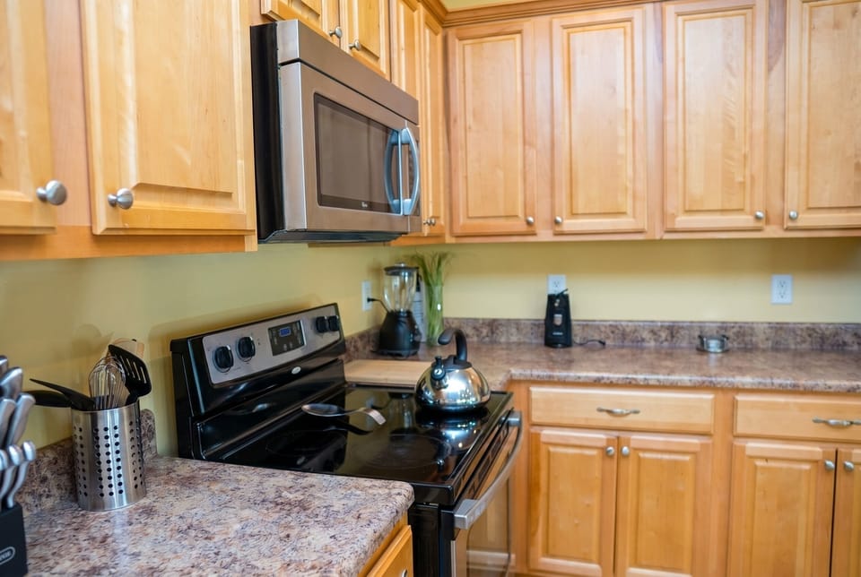 Bright kitchen with full appliances, generous counter space, and warm wood cabinets