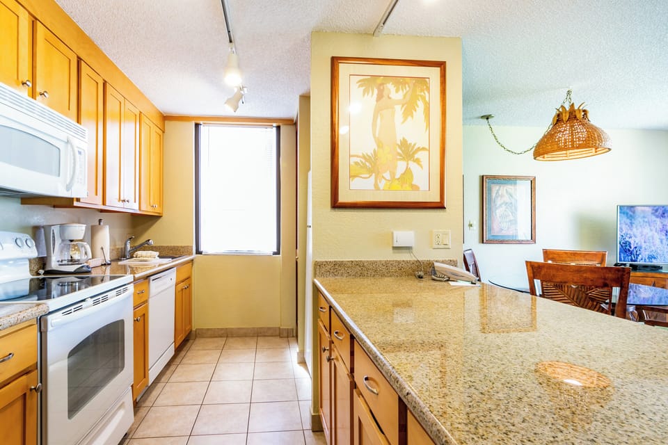 Your fully equipped kitchen awaits, featuring granite counters, warm wood cabinets, and everything you need to prepare meals during your stay.
