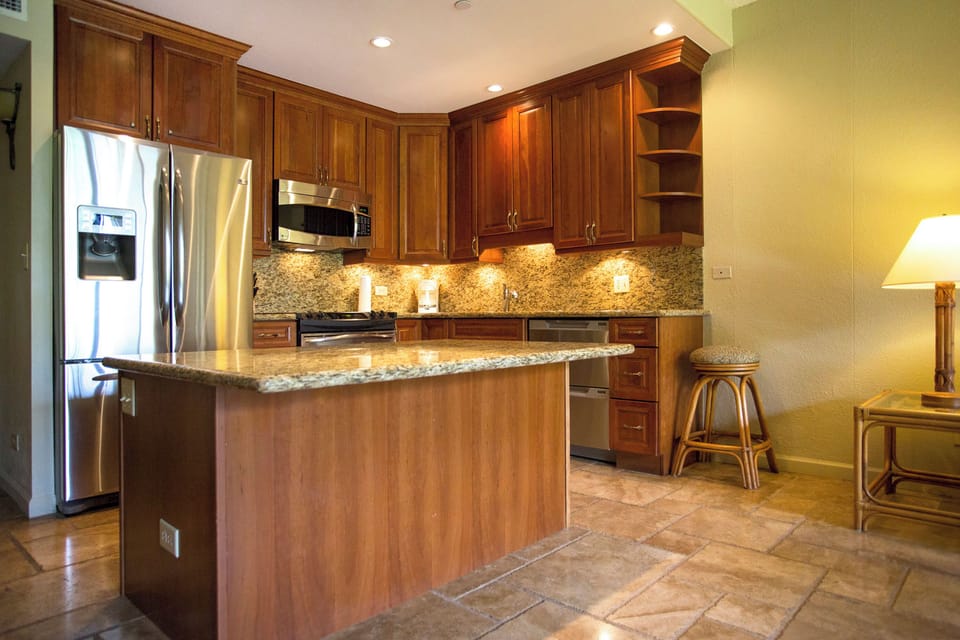 This well-appointed kitchen features rich wood cabinetry, granite countertops, stainless steel appliances, and under-cabinet lighting—perfect for preparing your favorite meals during your stay.