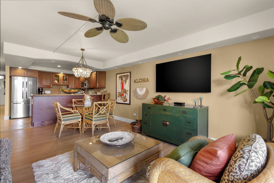 Relax in your tropical-inspired living space with bamboo ceiling fan, open kitchen, and vibrant island decor creating the perfect Hawaiian getaway vibe.