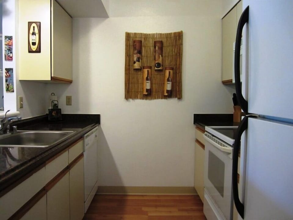 Your fully equipped galley kitchen features sleek black countertops, modern appliances, and warm wood floors—everything you need to prepare meals during your stay.