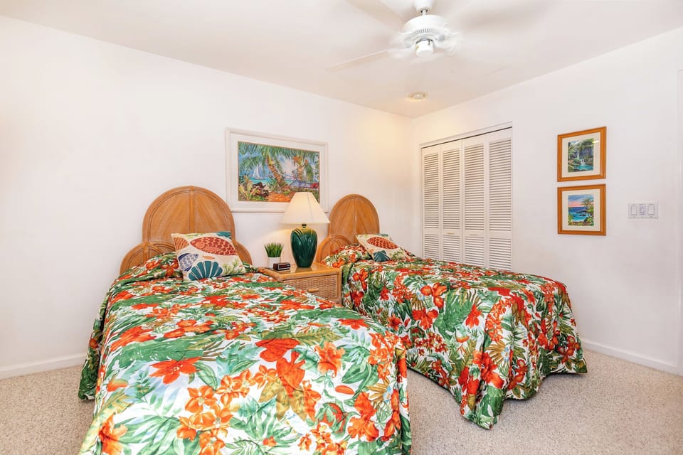Sink into plush twin beds dressed in vibrant tropical florals, with tropical artwork inviting you to dream of island escapes. Your retreat awaits in this bright, airy bedroom.