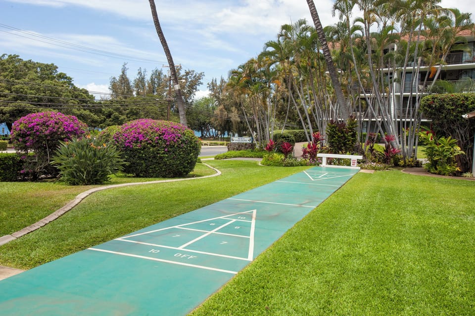 A cheerful hopscotch court awaits on lush tropical grounds, surrounded by vibrant bougainvillea and swaying palms—perfect for playful afternoons under the sun.