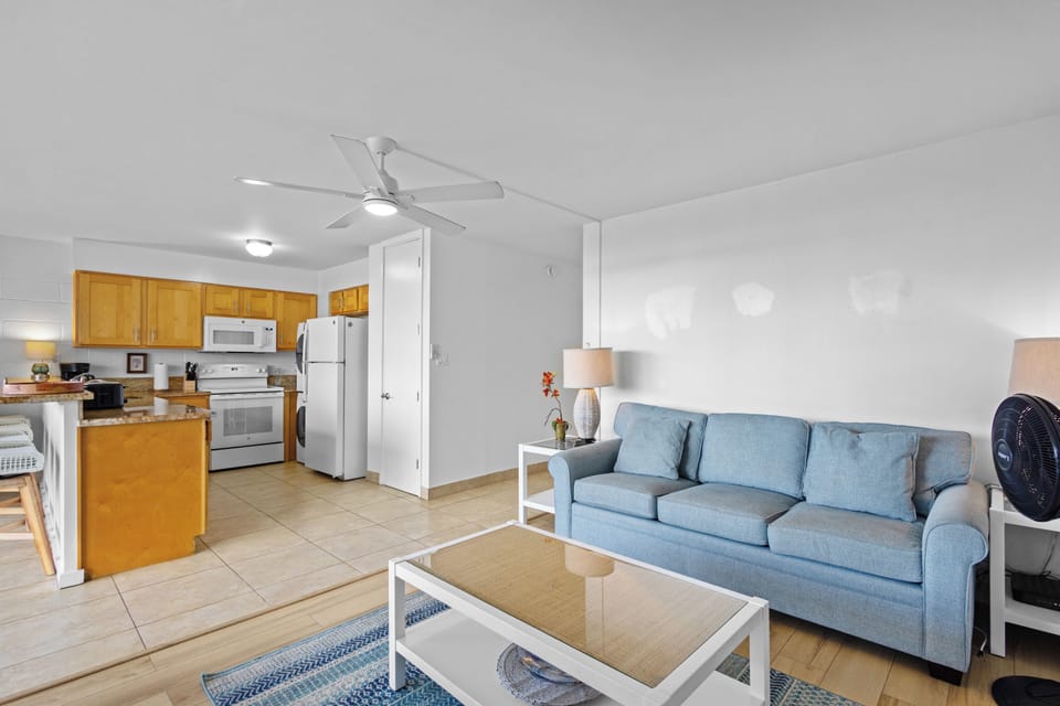 Relax in your airy open-concept living space with a fully equipped kitchen and comfortable seating—your coastal retreat feels effortlessly bright and welcoming.