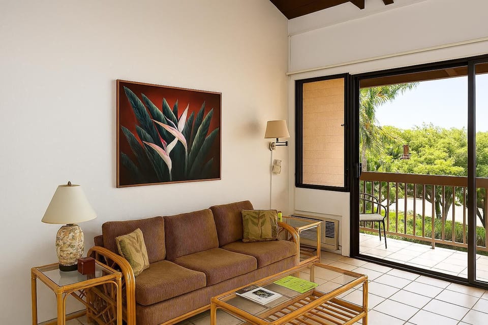 Unwind in your private living room, where tropical artwork and bright natural light create a peaceful retreat. Step onto your balcony to enjoy lush garden views and ocean breezes just beyond the palms.