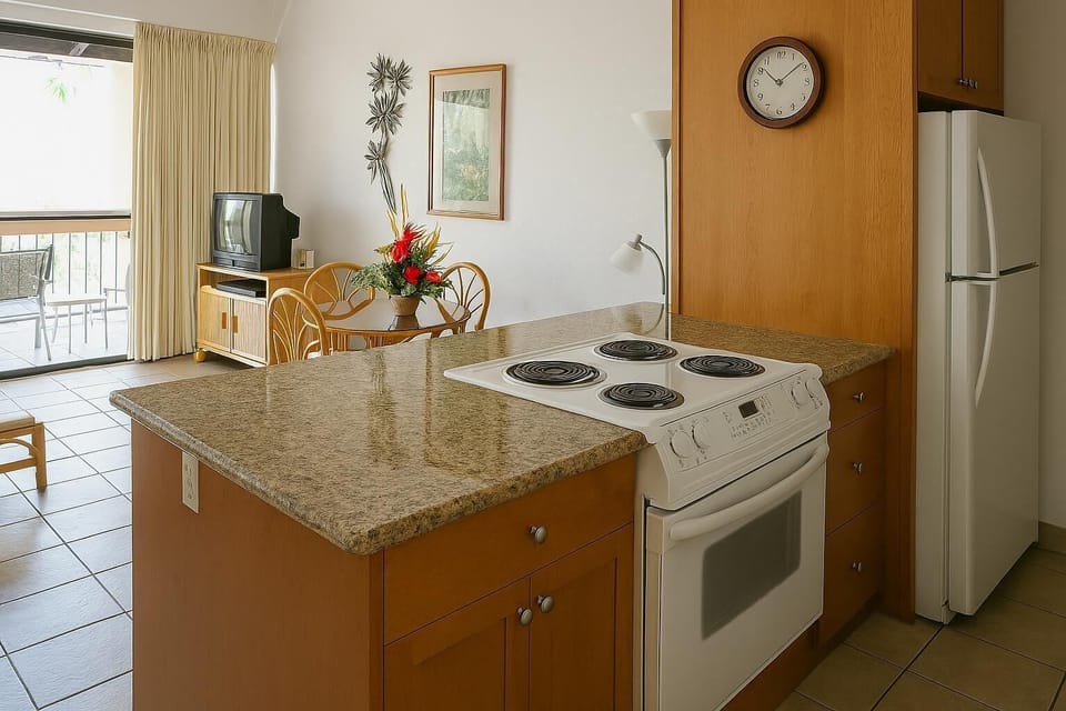 Your fully-equipped kitchen awaits with a spacious granite countertop, stove, fridge, and open view to your bright living area—everything you need to feel at home.