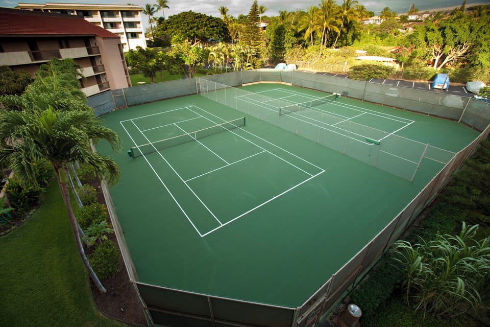 The property features well-maintained tennis courts surrounded by lush tropical landscaping, available for guest use in a scenic Hawaiian setting.