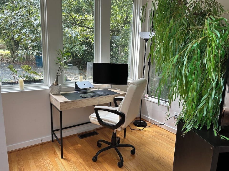 Compact desk area with monitor and plenty of natural light