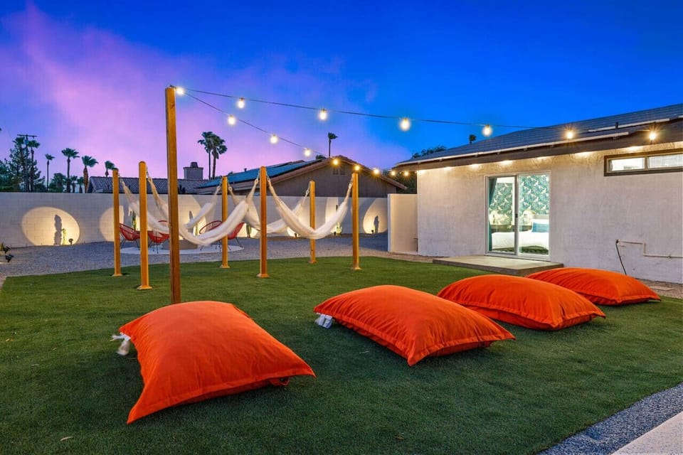 String-lit lawn w/ low loungers creates a relaxed spot to unwind under the desert night sky.