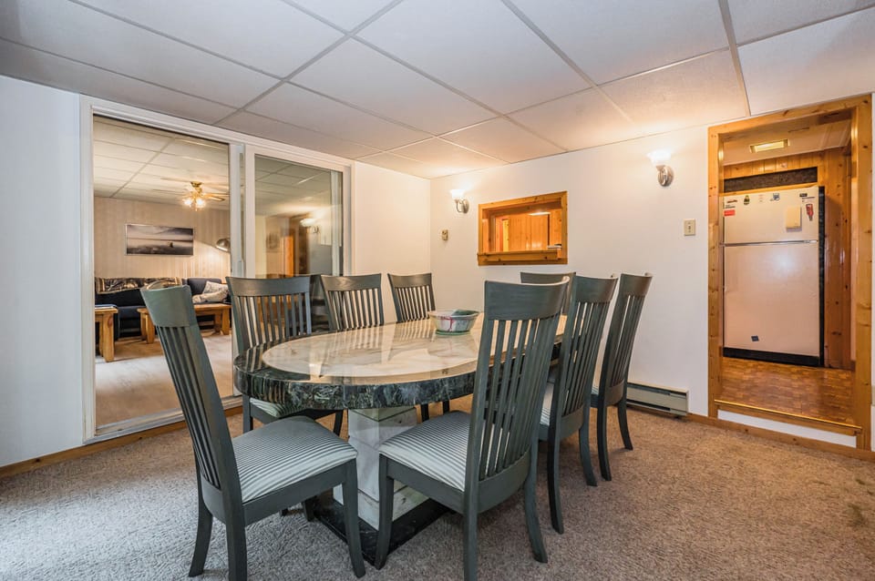 Comfortable chairs create an inviting atmosphere for both lively family dinners and peaceful breakfasts. It's a welcoming hub where stories are shared and memories made, all within the comfort of this charming woodland retreat